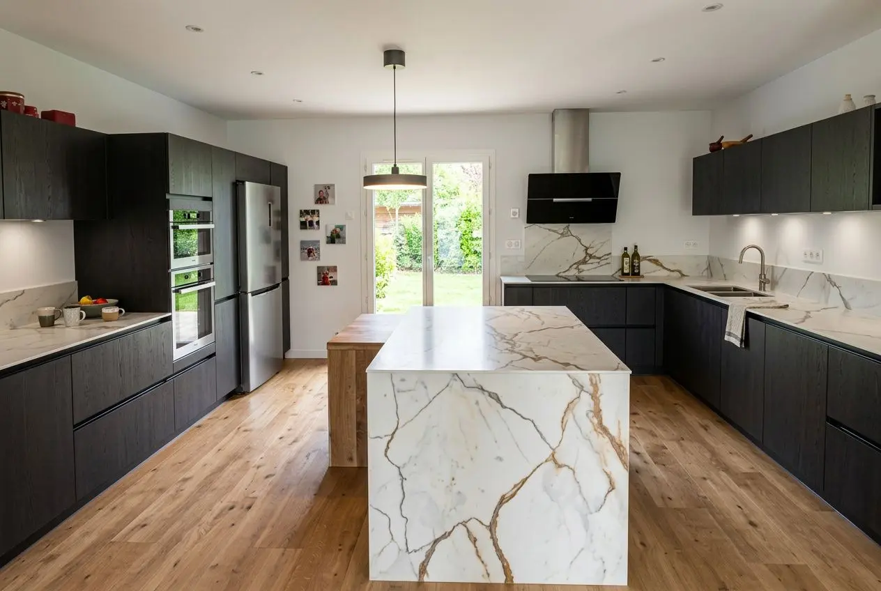 Cuisine rustique moderne bois: grande cuisine noire avec îlot en pierre marbrée, plan de travail et mur en marbre, bois clair au sol et touches modernes.