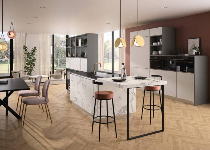 Cuisine ouverte moderne avec îlot central en marbre et plaque de cuisson, entourée de rangements gris clair et tabourets